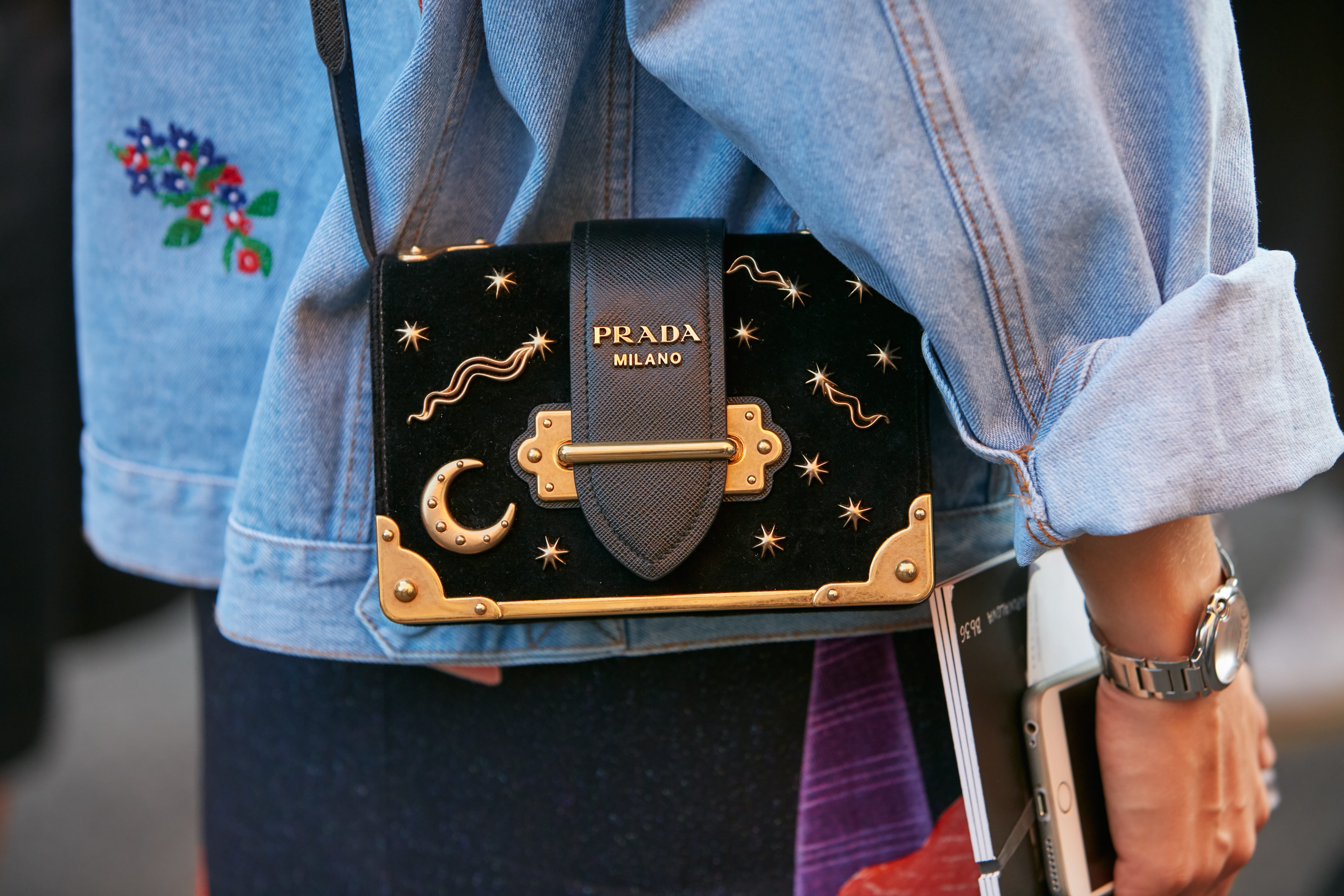 A fashion week attendee dons a Prada bag